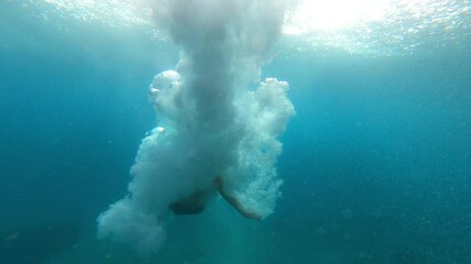 One man jumping to the water recorded from the under water - vacations and traveling at summer lifestyle and concept - holiday at the beach and swimming on the sea or ocean
