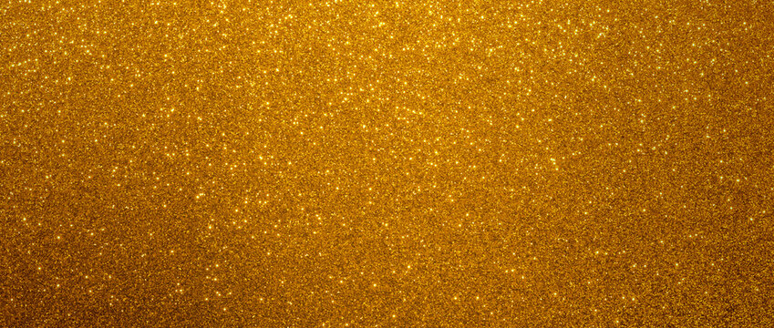 Golden glitter christmas background. Close-up shot of yellow glittery texture or new year or valentine day designs.