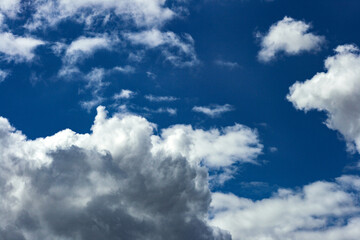 Naklejka na ściany i meble Nubes en un cielo azul intenso, fondo.