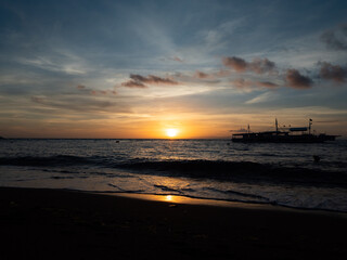 Stunning sunrise over the beach in Philippines. Diving boats waiting for early morning divers.