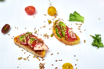 Toasts with vegetables, avocado, tomatoes, a set of seeds on a white background. Healthy food, diet concept.