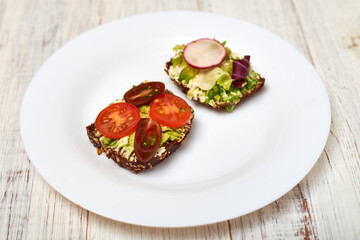 Slice of cereal bread with cream cheese, avocado and vegetables. Vegetarian sandwich.