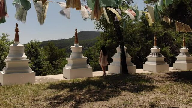 Female in Buddhist Garden with Prayer Flags and Stupas