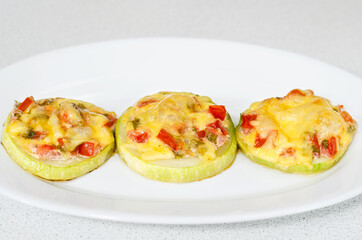 Baked zucchini stuffed with vegetables and herbs, sprinkled with cheese on top