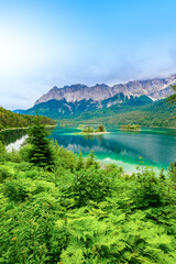 Small islands with pine-trees in the middle of Eibsee lake with Zugspitze mountain. Beautiful...