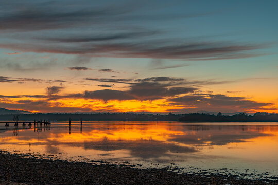Clouds, reflections and sunrise over the bay