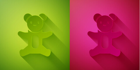 Paper cut Teddy bear plush toy icon isolated on green and pink background. Paper art style. Vector.
