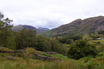 Fototapeta premium Mountain landscape view with blue sky and clouds, from Stang End Farm, Little Langdale, Coniston, in the Lake District, Cumbria, England.