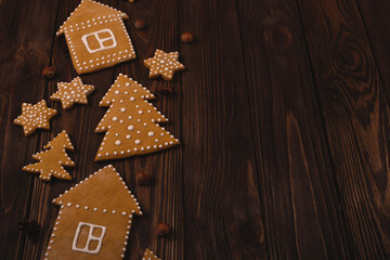Christmas gingerbread cookies in shape of trees6 houses and stars on a wooden table. Top view,...