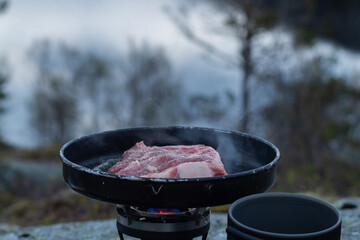Frying food outdoors with camping kitchen gear, using gas and hiking frying pan