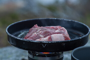 Frying food outdoors with camping kitchen gear, using gas and hiking frying pan