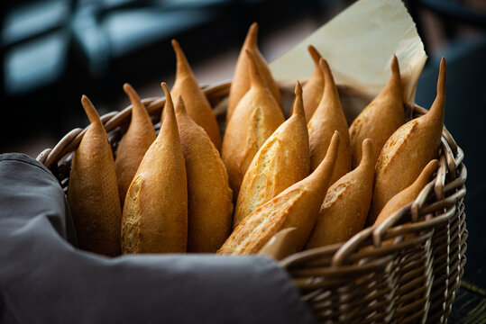 Wicker Basket Full Of Baguettes, Tasty Delicious Crusty Bread In Bakery Shopfront.