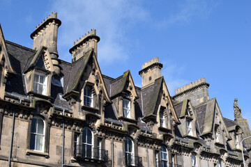 Chimneys & Dormer Windows on Roof of Victorian Houses against Blue Sky 
