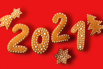 Gingerbread cookies in the shape of the numbers for the new year 2021 balancing on a red background. Anti gravity