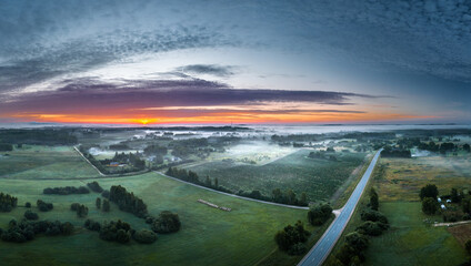 Fototapeta na wymiar Aerial view of highway leading through a foggy countryside. Beautiful texture in the sky. Aerial landscape.