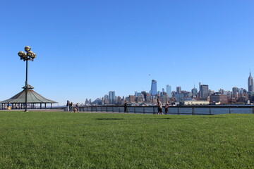 Grass of a park in Hoboken, New Jersey, and the Manhattan skyline at the back - Maxwell Place Park