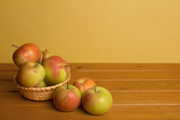 apples in little basket on wooden surface 