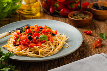 Italian spaghetti alla Pultanesca with tomatoes and olives. Served without meat and cheese.