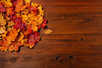 Naklejka na ściany i meble Wooden background. Arranged autumn leaves and pumpkins. Top view.