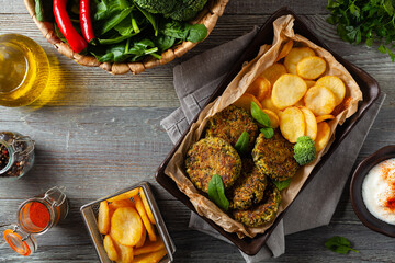 Vegetarian spinach and broccoli meatballs, served with yogurt dip and toasted potatoes. Top view.