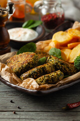 Vegetarian spinach and broccoli meatballs, served with yogurt dip and toasted potatoes. Front view.