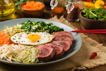 Korean beef with sprouts, spinach and fried egg.