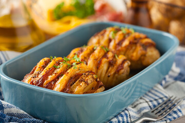 Baked potatoes in Swedish. Hasselback. Stuffed with cheese and bacon. Top view.