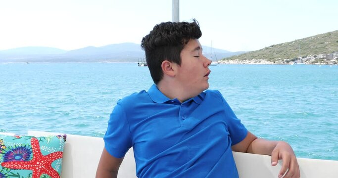 Young boy having a nausea seasickness during the boat trip