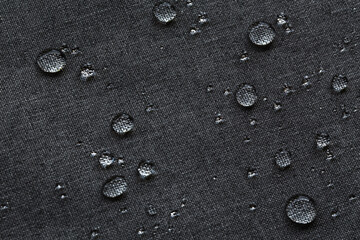 Waterproof droplets on fabric. Black Canvas Polyester texture synthetical for background. Black...