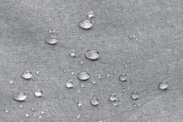 Waterproof droplets on fabric. Grey Canvas Polyester texture synthetical for background. Black...