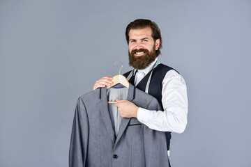 Working on new design. tailor in his workshop. Handsome bearded fashion man in costume suit. Man in...