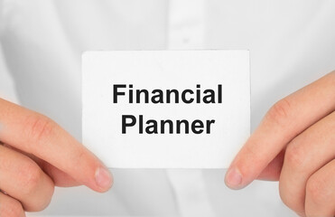 Man's hands take a card with words Financial Planner, finance and business concept.