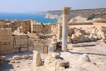 Ruins of the Episcopal Basilica and a well preserved carved column with blue waters of Mediterranean Sea at the background at the Neolithic period Kourion Ancient city in Cyprus 