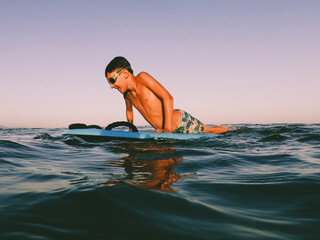 A young boy learning in body board outdoors in the shoreline in a sunny day of summer