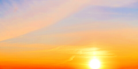 Golden sunset sky landscape background. Natural color of evening cloudscape with setting sun. Orange clouds on yellow sky. Colorful panorama wallpaper. Ultra wide panoramic view. Banner template