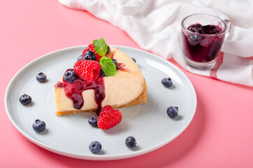New York Cheesecake with blueberry jam and decoration with fresh raspberry and blueberry.