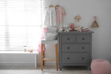 Stylish chest of drawers and accessories in child room