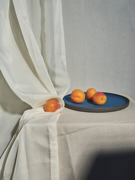 Apricots on plate with curtain