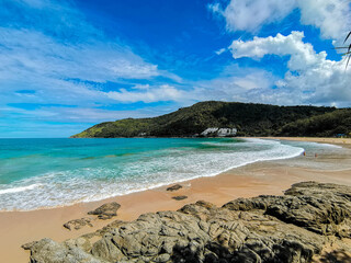 White ocean wave bubble and blue sky at Nai Harn Beach Phuket.