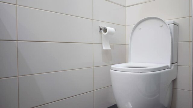 Black-haired brunette teenager vomiting in white bathroom