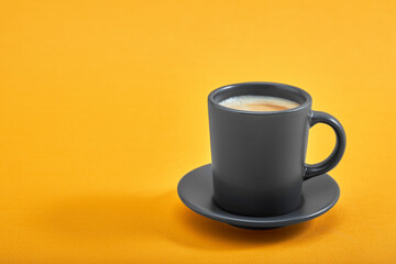 Cup of black coffee on a yellow background. Concept: Good morning, energy boost, motivation. Space for text