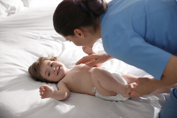 Fototapeta na wymiar Orthopedist examining cute little baby on bed