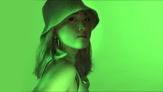 Korean model in studio with colored green light and water reflection with 90s fashion style 