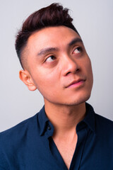 Fototapeta premium Face of young Asian businessman thinking and looking up