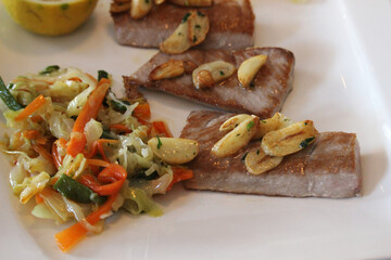 Tuna belly cooked on the grill with garlic and vegetables