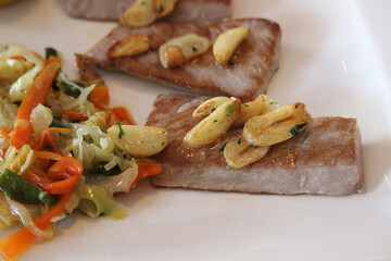 Tuna belly cooked on the grill with garlic and vegetables