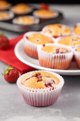 Strawberry muffins with fresh strawberries on grey concrete background