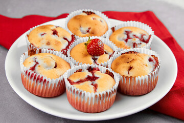 Strawberry muffins with fresh berries on white plate on linen napkin background