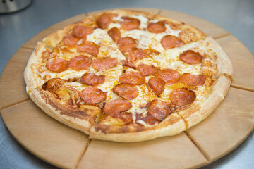 Pepperoni pizza cut into pieces on the kitchen table.