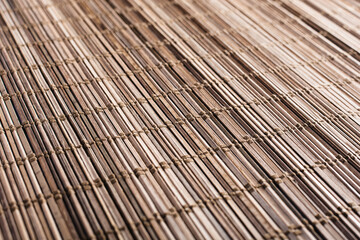 the texture of the makisu bamboo Mat is close up at a sharp angle of view with a selective depth of field